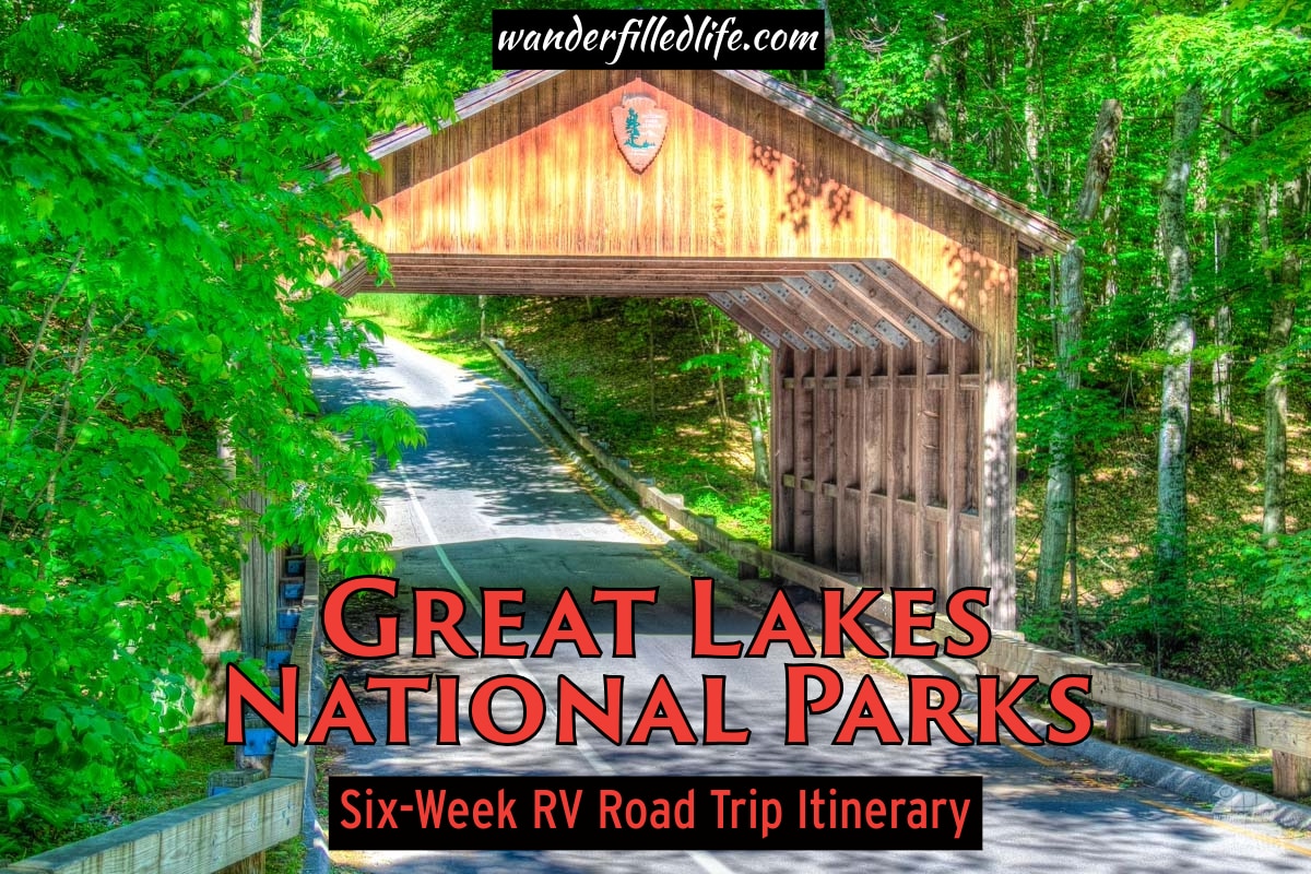 Photo with text overlay. Photo shows a road lined with trees passing under a wooden covered bridge. Text reads Great Lakes National Parks Six Week RV Road Trip Itinerary.