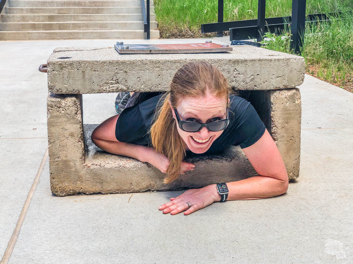 Bonnie Sinclair squeezing through the concrete test at Jewel Cave National Monument.