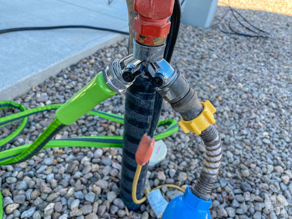 A hose splitter allowing two connections at a water spigot.