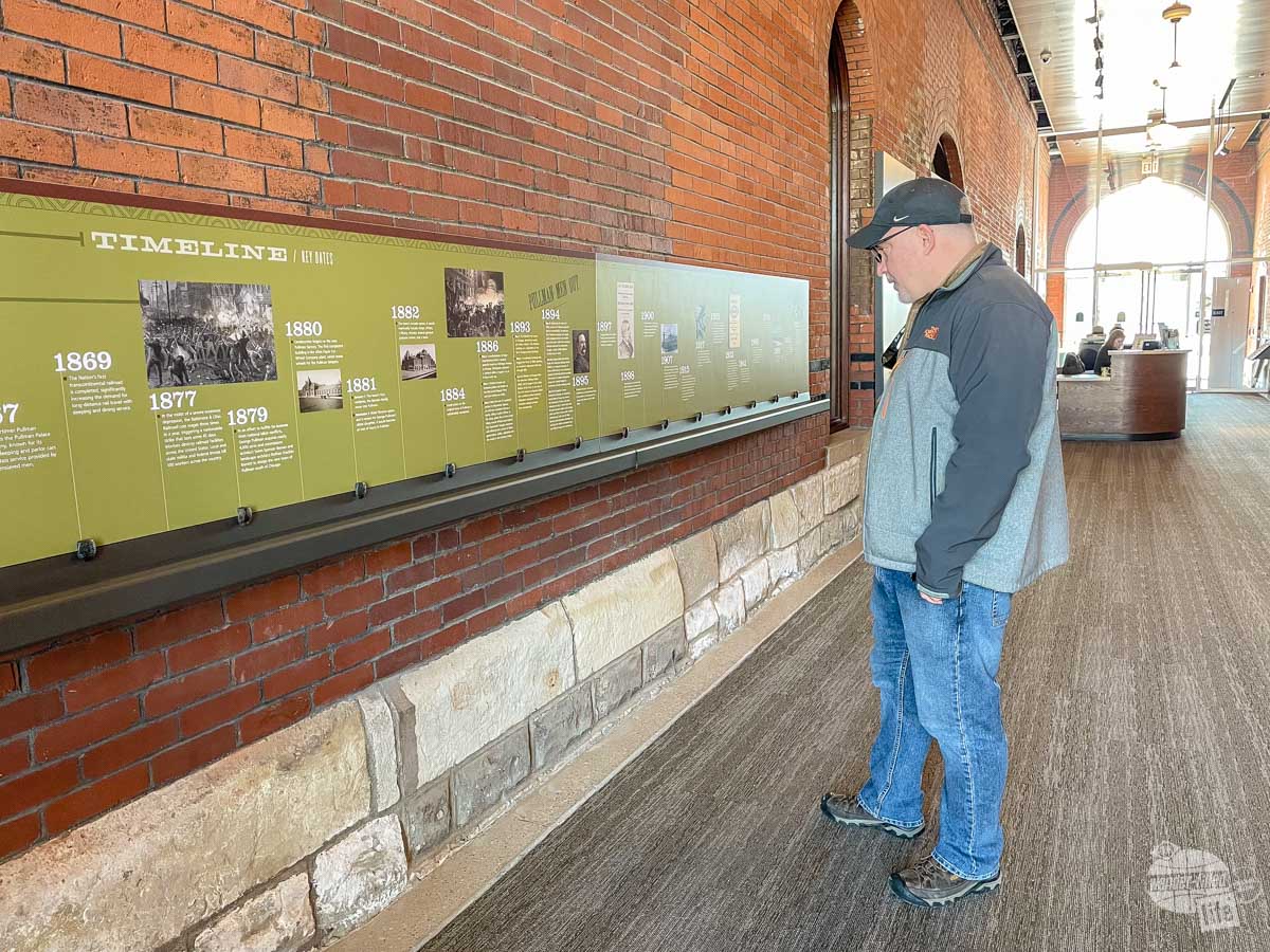 Grant views a timeline of events at the Pullman National Historical Park placed on a brick wall.