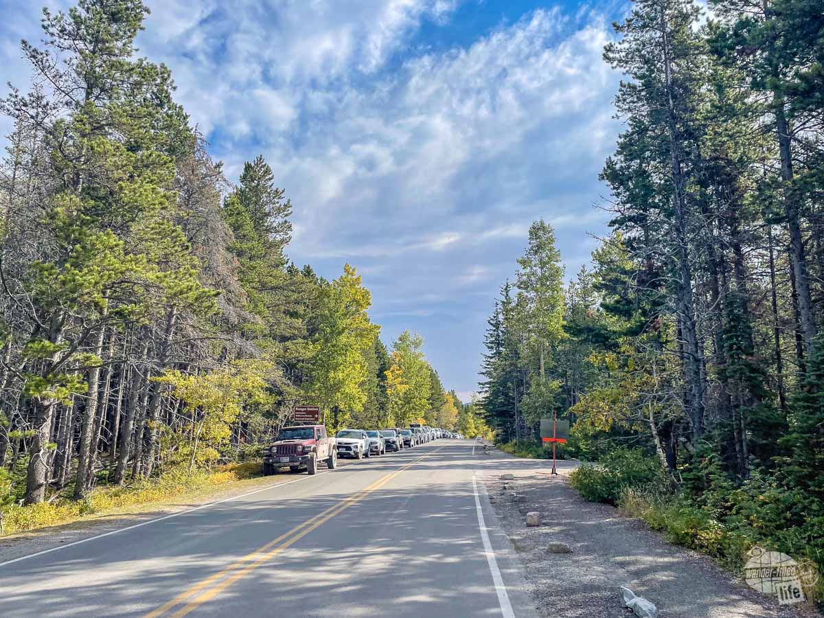 A line of cars parked near the Grinnell Glacier Trailhead in Glacier National Park