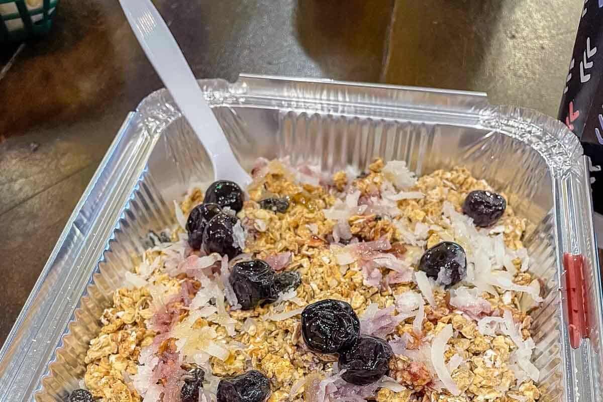 A bowl of huckleberry yogurt with granola. 