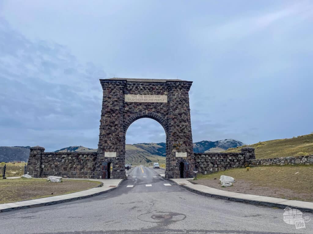 A large stone arch spans a roadway.