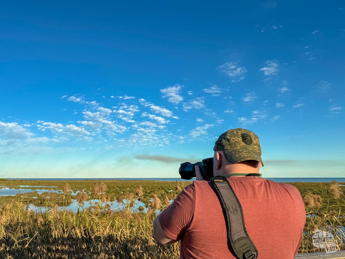 Grant uses a DSLR camera to takes pictures at a marsh