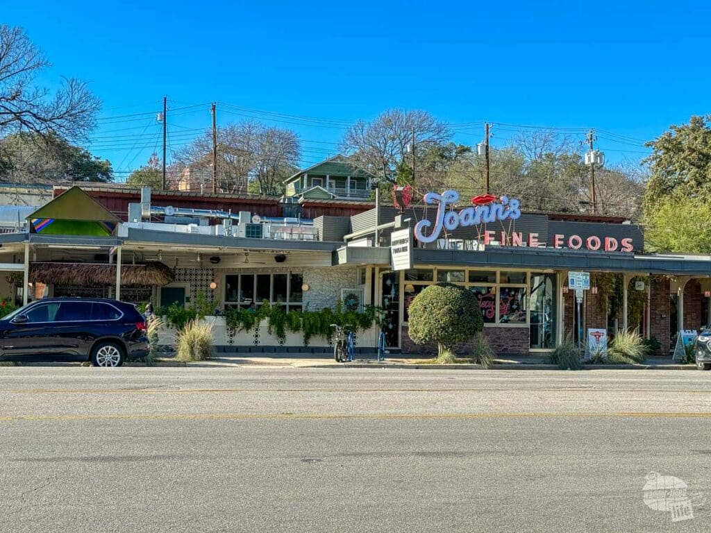 A one-story restaurant building with a covered patio on one side. A sign on top reads Joann's Fine Foods.