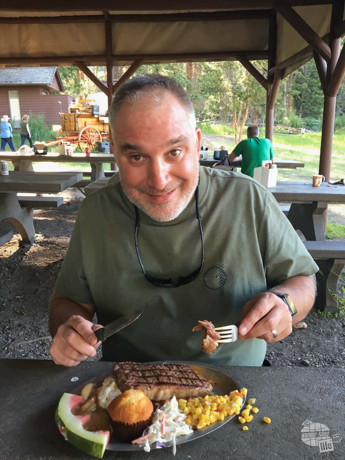 Grant Sinclair enjoying a bite of steak at the Old West Cookout in Yellowstone National Park.