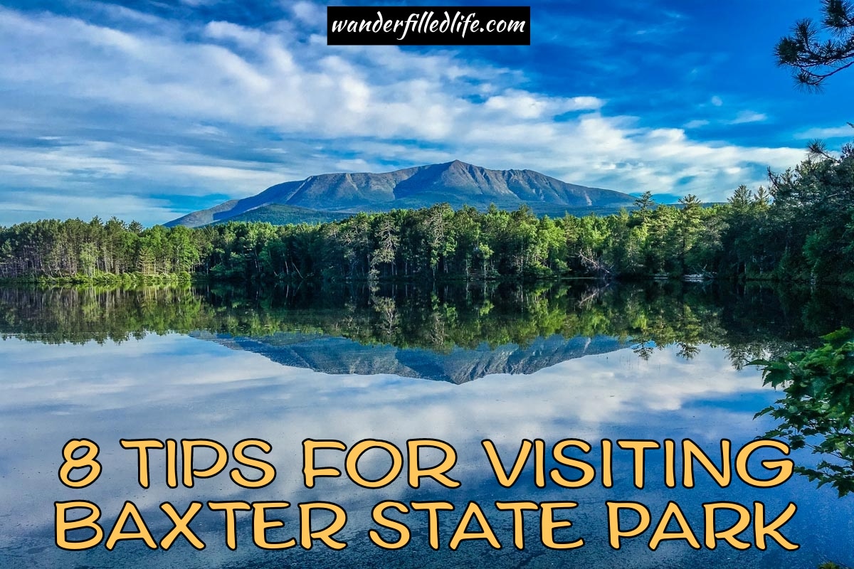 Photo with text overlay. The picture shows the still waters of a lake surrounded by trees, which are reflected in the water. A mountain rises in the background against a blue sky with white clouds. Text reads 8 tips for visiting Baxter State Park.