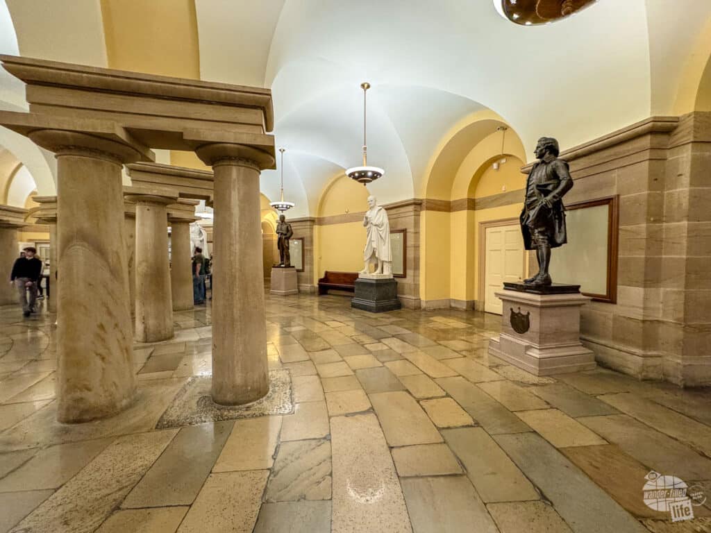 A rounded room with statues agains the wall.