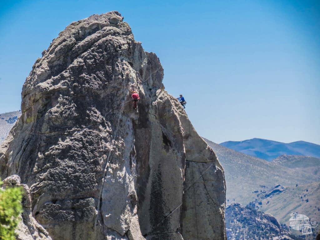 A pair of climbers making their way to the top of a granite spire.