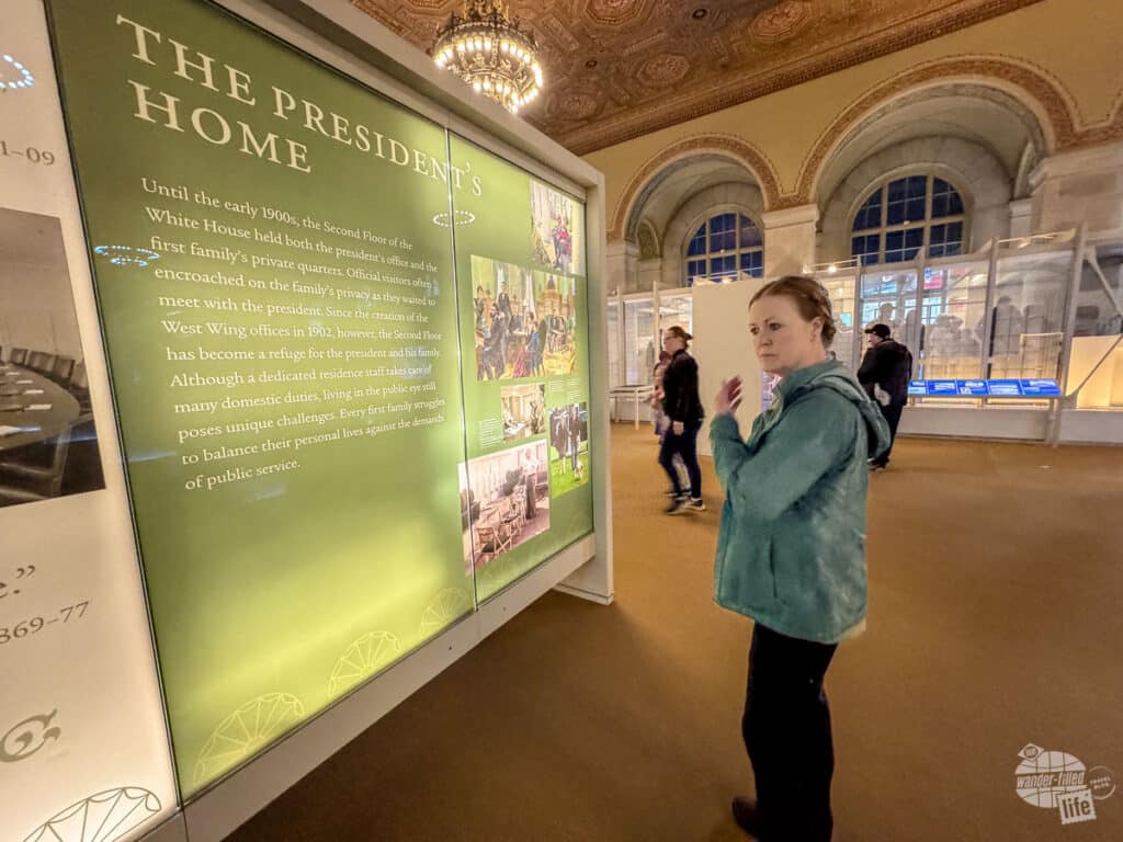 Bonnie reading an exhibit sign on the use of the White House as the President's Home.