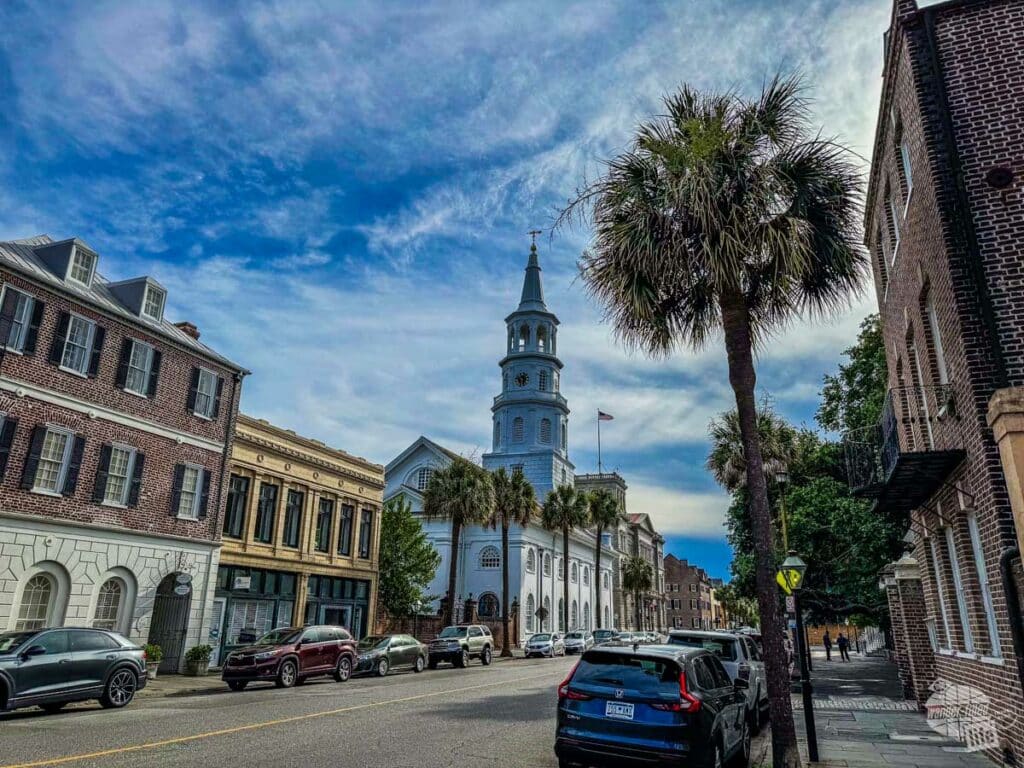 An old church steeple along a street filled with historic homes.